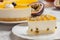 Cheesecake with the passion fruit coulis on the black and wooden background