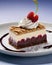 Cheesecake with raspberries and cherry on a white plate.
