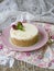 Cheesecake with raspberries and mint on a pink plate on a wooden table with floral fabric and laces. Close up, copy space