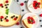 Cheesecake with two slices of cake with fresh raspberries, blueberries, jam and mint on marble background. top view