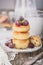 Cheesecakes or cottage cheese pancakes, decorated with berries and mint, lie in a plate on a beautifully decorated table on a