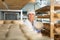 Cheesemaker checking aging process of cheese in maturing chamber