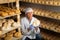 Cheesemaker checking aging process of cheese in maturing chamber