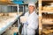 Cheesemaker checking aging process of cheese in maturing chamber