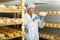 Cheesemaker checking aging process of cheese in maturing chamber