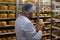 Cheesemaker checking ready product in a storage room