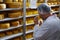 Cheesemaker checking ready product in a storage room