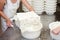 Cheesemaker filling colanders with fresh curd