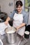 Cheesemaker mixes curdled milk with a whisk