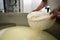 A cheesemaker prepares a form of Parmesan cheese using fresh curd. Cheese-making, separating the curds and whey.