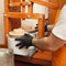 cheesemaker puts cheese under press, whey. Home production, business, portrait