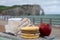 Cheeses of Normandy, round camembert cow cheese, yellow livarot, heartshaped neufchatel and view on alebaster cliffs Porte d`Aval