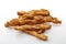 Cheesy flavor cracker, salty treat and food rich in carbohydrates group of many twisted golden cheese sticks isolated on white