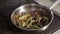 Chef adding tomato sause to frying pan with vegetables and meat.