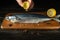 The chef adds fresh lemon juice to raw mackerel fish before cooking with ingredients and aromatic spices