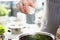 Chef adds salt from salt bowl to dish closeup