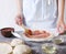 Chef applying tomato sauce on the pizza dough top.Preparation of classic italian pizza