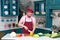 Chef in apron and bonnet cutting yellow paprika for salad