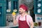 Chef in apron and cap sniffing yellow paprika and smile. Bearded