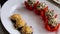 The chef arranges mushrooms stuffed with cheese on a white plate