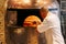 Chef Baking Caprese Bianca Pizza inside wood burning pizza oven