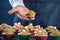 Chef in a black apron holding the fresh baked muffins in hands. Concept of confectionery cooking