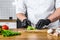 A chef in black gloves prepares guacamole from fresh avacado Hass