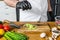 A chef in black gloves prepares guacamole from fresh avacado Hass