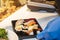 A chef with blue plastic gloved hands assembling a plate of sushi for delivery