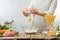 The chef breaks egg into glass bowl for cooking pasta alla carbonara. Backstage of preparing traditional italian dish on white