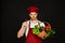 Chef in burgundy uniform holds red chili in hand.