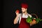 Chef in burgundy uniform holds red pepper in hand.