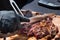 Chef carving a portion of grilled rib eye meat