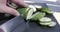 Chef chopped pickled cucumber on a black table