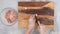 Chef chopping garlic on wooden chopping board.