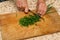 Chef chopping a green onion with a knife on the cutting board