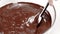 Chef Confectioner mixing dark melted chocolate in glass bowl slow mo close up