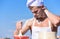 Chef cook preparing dough for baking. Cook or chef with muscular shoulders and chest mixing flour in bowl. Man on