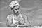 Chef cook preparing dough for baking with flour. Baker concept. Man on busy face wears cooking hat and apron, sky on