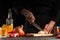 Chef cook slices onions in the kitchen on a dark background with vegetables, close-up