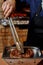 A chef cooking beef steak and turns it over with tongs on a kitchen in a restaurant . Hands and meat close up.