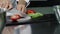 Chef cooking fresh salad at kitchen. Closeup chef hands cutting tomato.