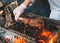 Chef Cooking steak. Cook turns the meat on the fire.