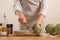 Chef cooks artichoke on a light background, concept cooking tasty and healthy food, menu, recipe book, detox, restaurants