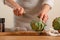 Chef cooks artichoke y slicing it on a light background, concept cooking tasty and healthy food, menu, recipe book, detox,