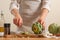 Chef cooks artichoke y slicing it on a light background, concept cooking tasty and healthy food, menu, recipe book, detox,