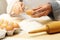 Chef cracking egg with knife over flour heap