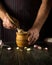 The chef crushes the garlic with a wooden pestle and mortar. We are preparing a national dish. Close-up of a chef hands while