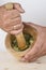 Chef crushing garlic and parsley with mortar and pestle in the k