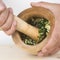 Chef crushing garlic and parsley with mortar and pestle in the k